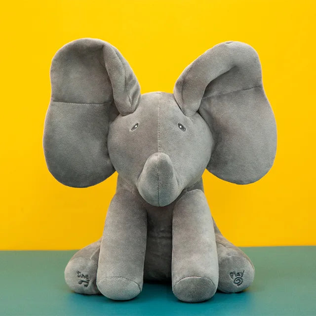 Gray elephant plush with raised ears and feet labeled Sing and Play