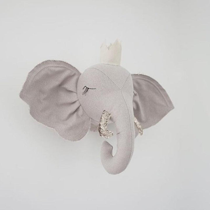 Gray elephant plush head displayed on a wall, with stitched closed eyes and textured tusks
