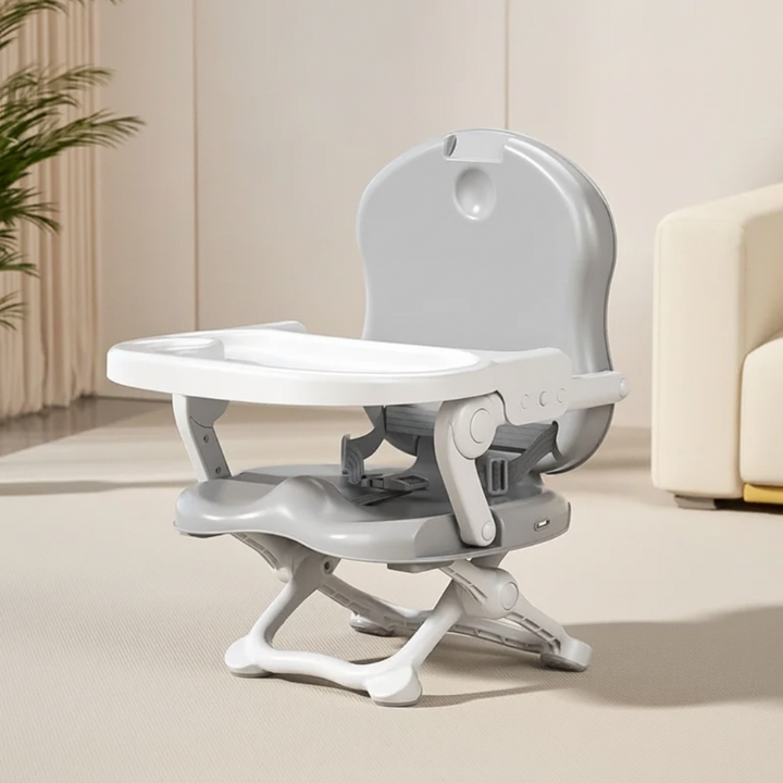 Gray compact high chair with a white tray and folding base