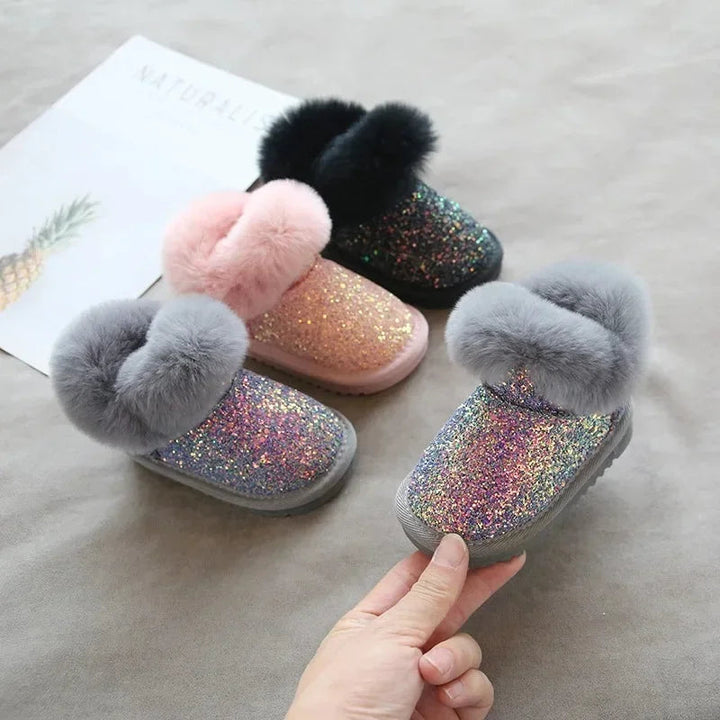 Gray glitter winter boot held beside pink, black, and gray boots.