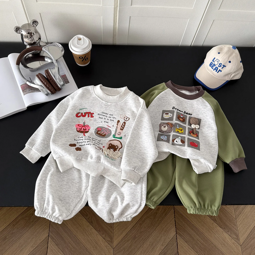Gray illustrated and green bear-print sweatshirt and pants sets laid side by side