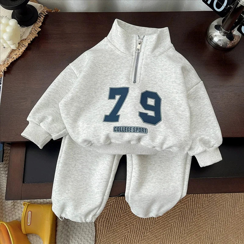 Gray half-zip sweatshirt laid over matching joggers with navy 79 graphics