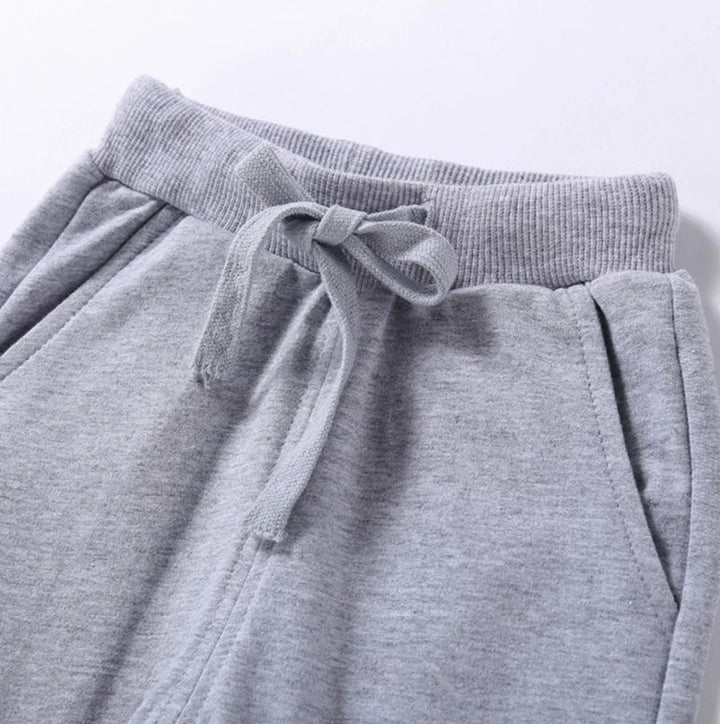 Close-up of a gray jogger waistband with a tied drawstring and side pockets