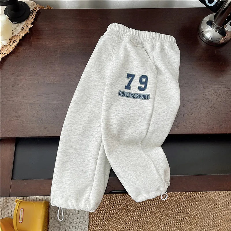 Gray joggers with one leg folded across the other and a navy 79 graphic