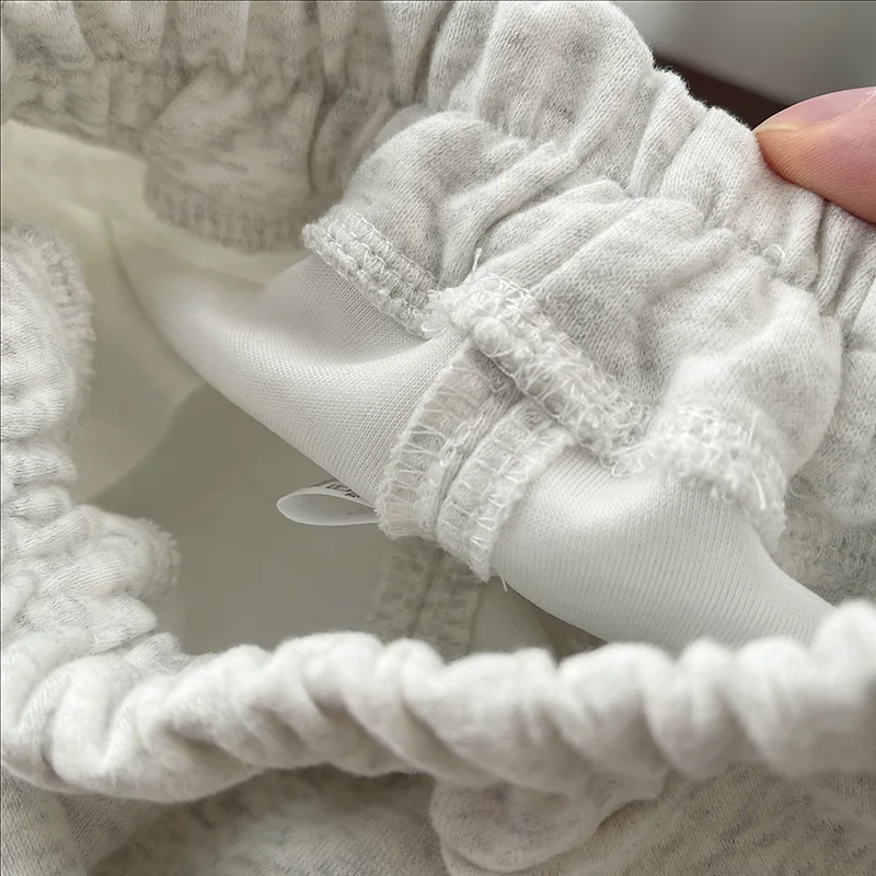 Close-up of elastic gathering and interior stitching on the gray joggers