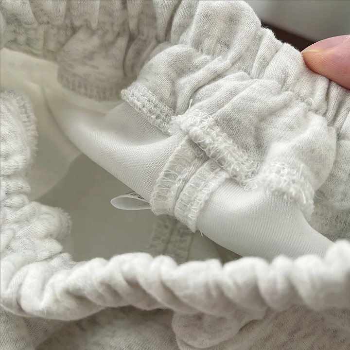 Close-up of elastic gathering and interior stitching on the gray joggers