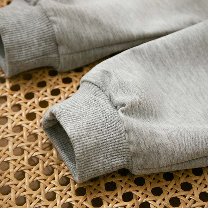 Close-up of ribbed ankle cuffs on the gray pants