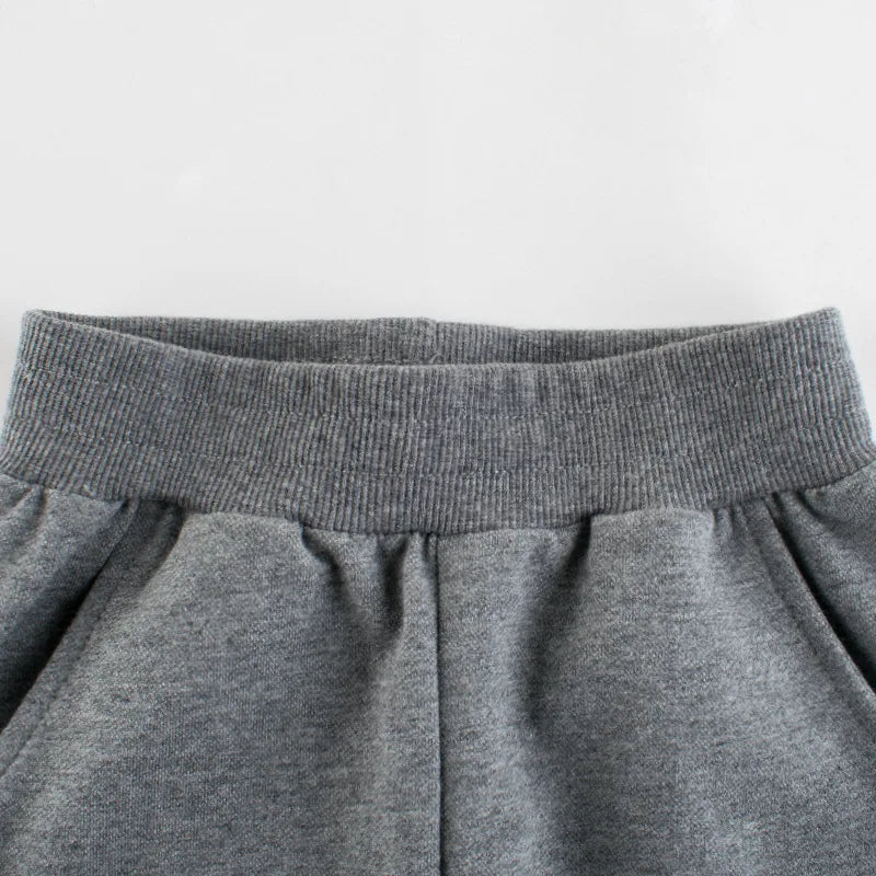 Close-up of the ribbed elastic waistband and pockets on gray sweatpants