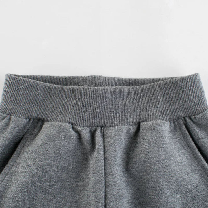 Close-up of the ribbed elastic waistband and pockets on gray sweatpants