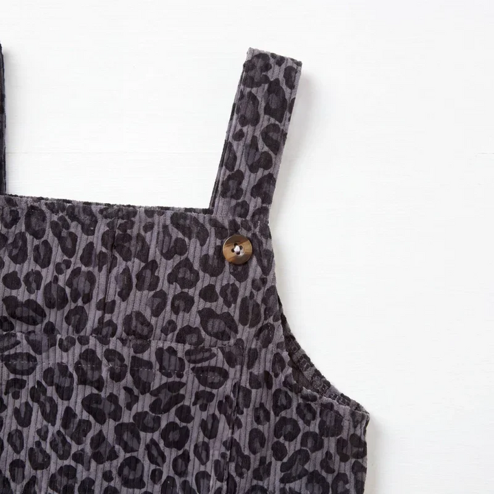 Gray leopard print overalls showing a shoulder strap and round button