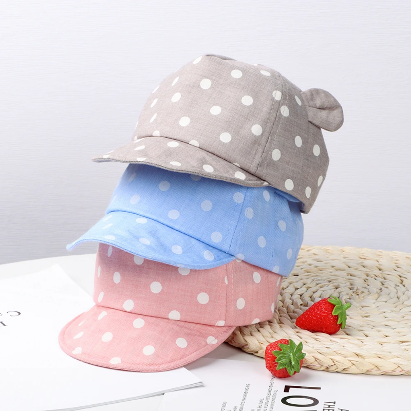 Gray, light blue, and pink polka dot caps stacked to show their colors and rounded ears.