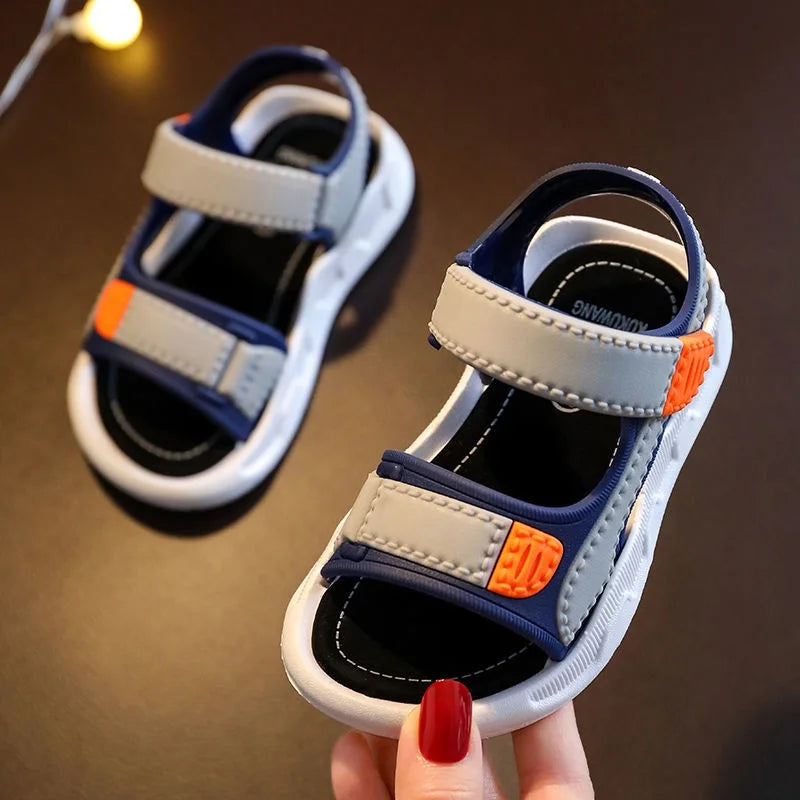 Front view of a gray and navy sandal with two straps and orange accents