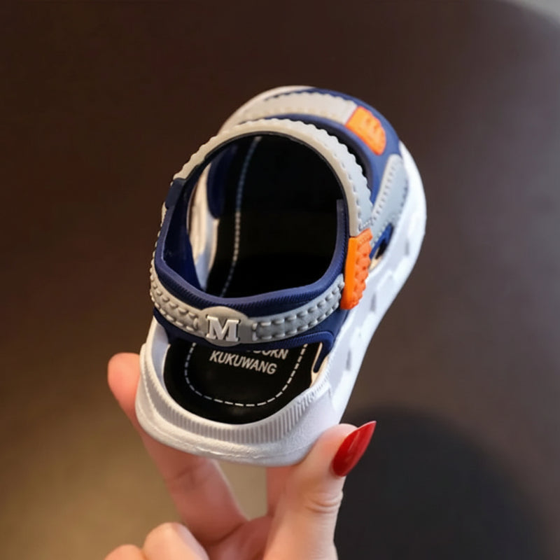 Rear view of a gray and navy sandal showing the heel strap and white sole