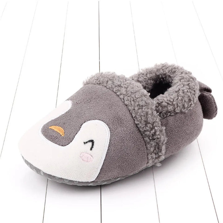 Gray penguin baby slipper with a white face and fuzzy cuff.