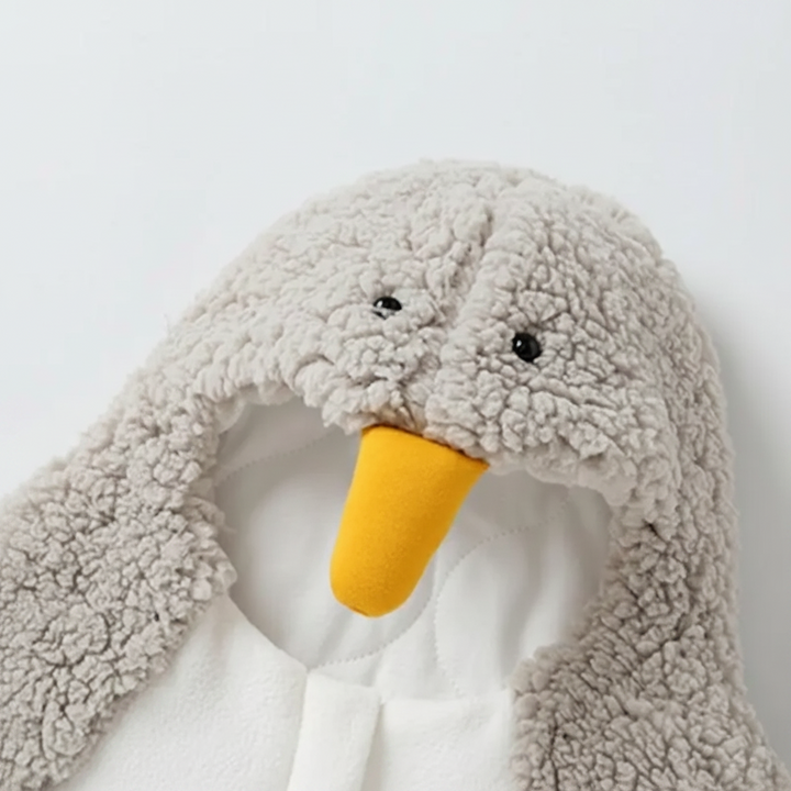 Close-up of the gray penguin hood with eyes and a yellow beak