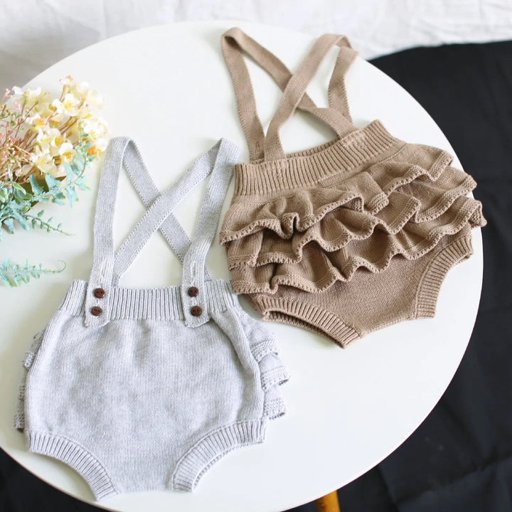 Gray knit romper beside a taupe romper showing its layered ruffle back
