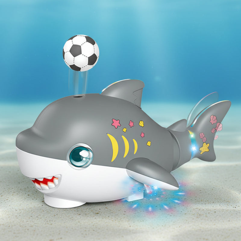 Gray shark toy with a floating soccer-style ball and colorful lights beneath its fins