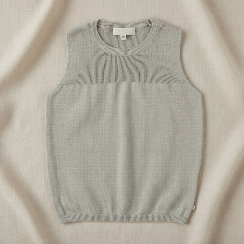 Gray sleeveless knit top with a textured yoke and ribbed hem