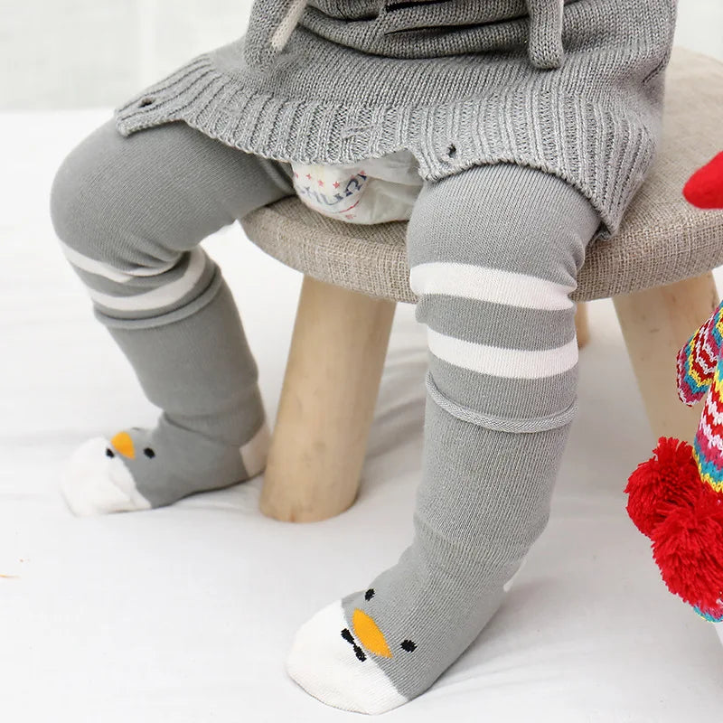 Child wearing gray striped leg warmers over leggings with coordinating gray animal-face socks.