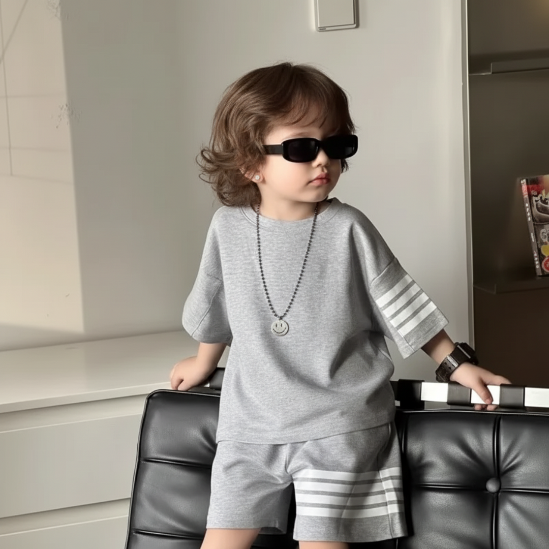 Child wearing the gray crew-neck T-shirt and matching shorts with white stripe details.