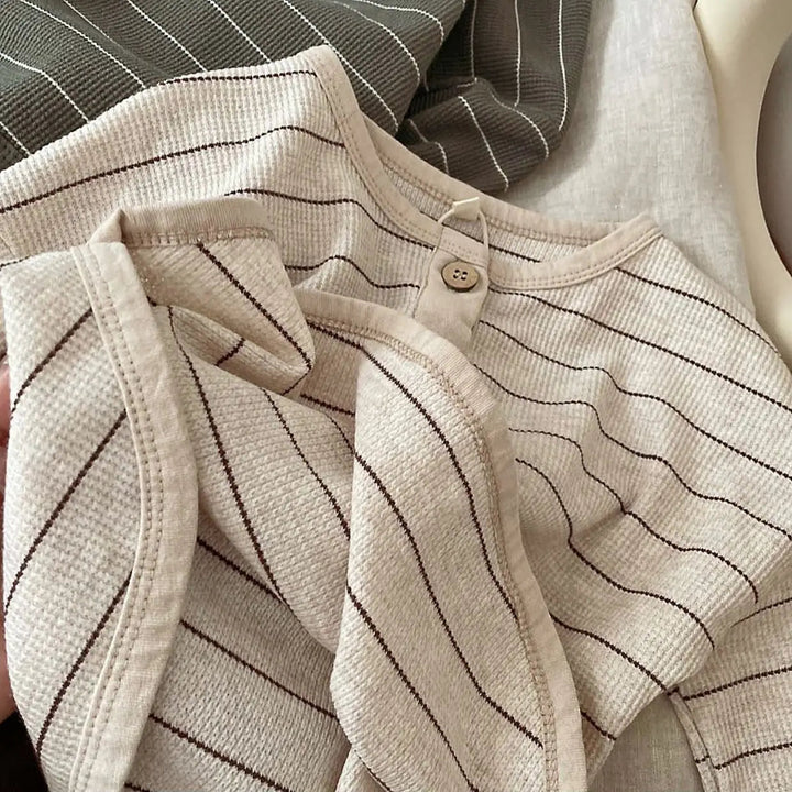 Light gray striped shirt showing the round neckline, two buttons, and folded sleeve