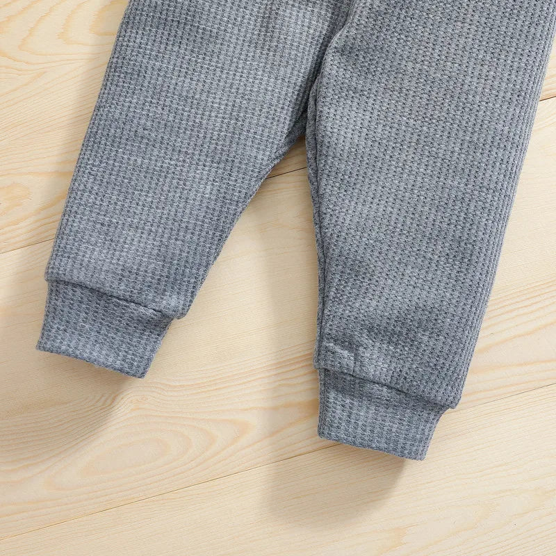 Gray baby pants showing textured fabric and cuffed ankles