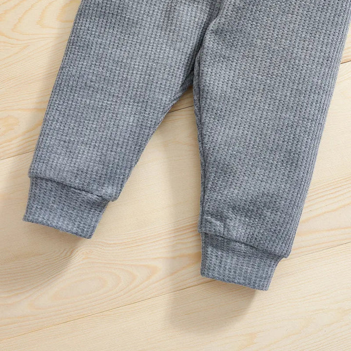 Gray baby pants showing textured fabric and cuffed ankles