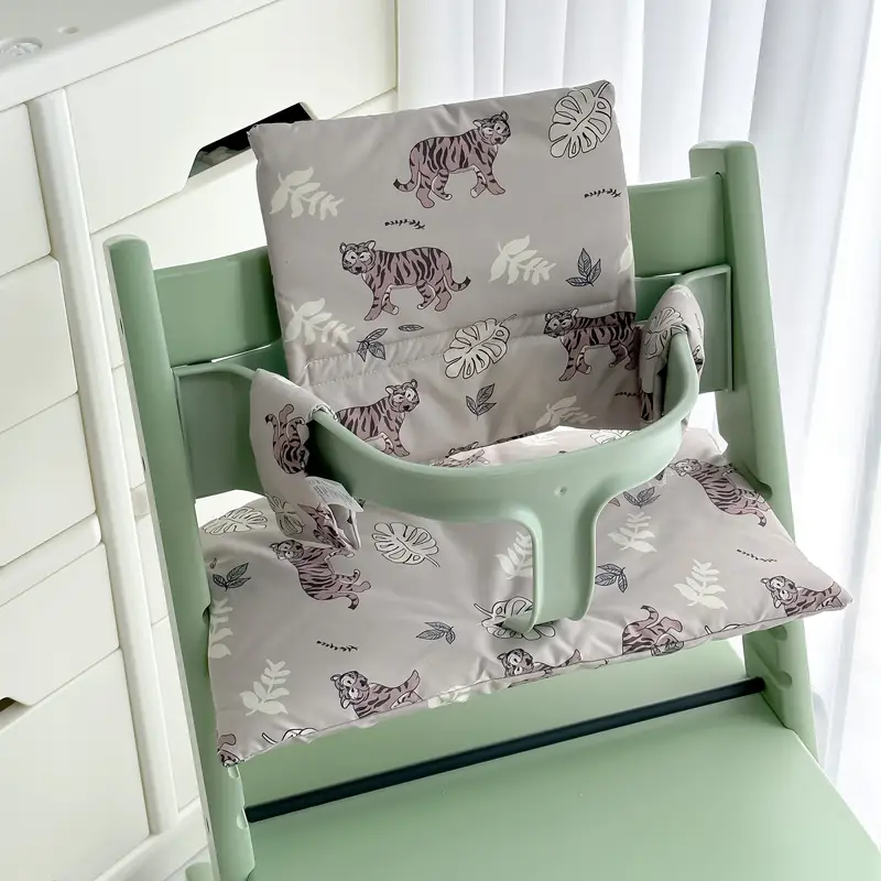 Gray tiger-and-leaf seat and back cushions fitted to a mint-green high chair