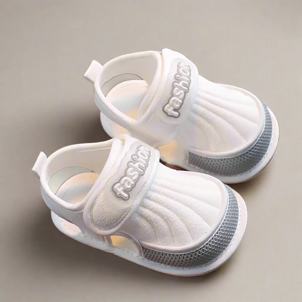 Pair of gray-trim baby sandals with closed toes and open sides