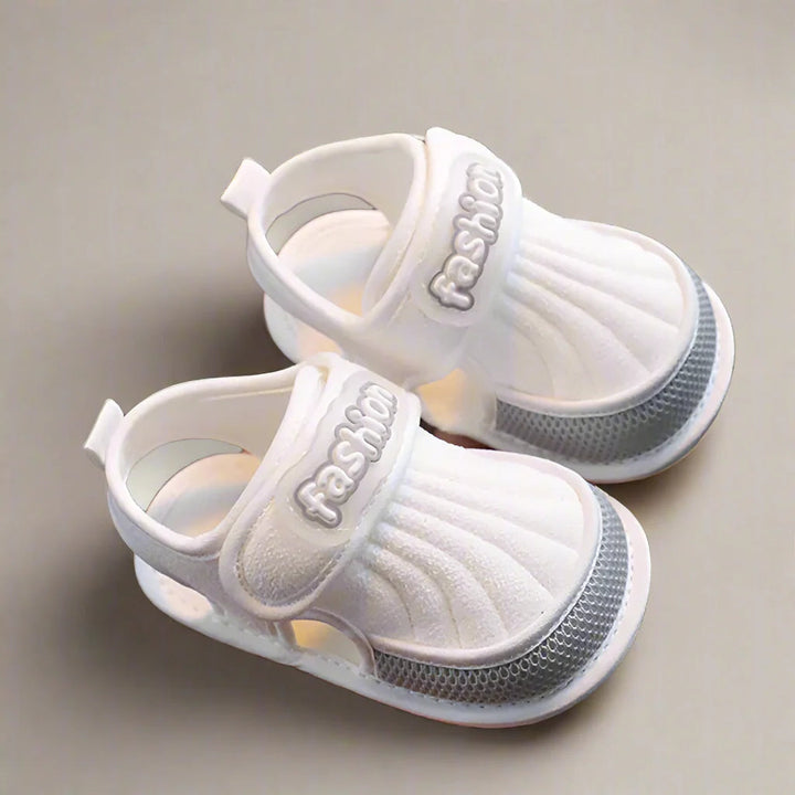 Pair of gray-trim baby sandals with closed toes and open sides