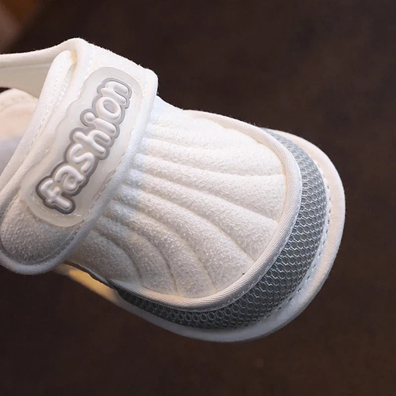 Close-up of a gray-trim baby sandal with a textured closed toe and strap