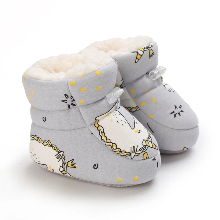 Gray unicorn-print baby slippers with yellow accents and soft-lined cuffs