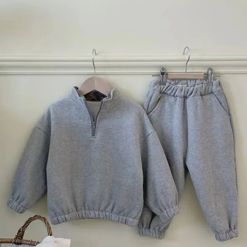 Gray zip-neck fleece top and elastic-waist pants hanging together