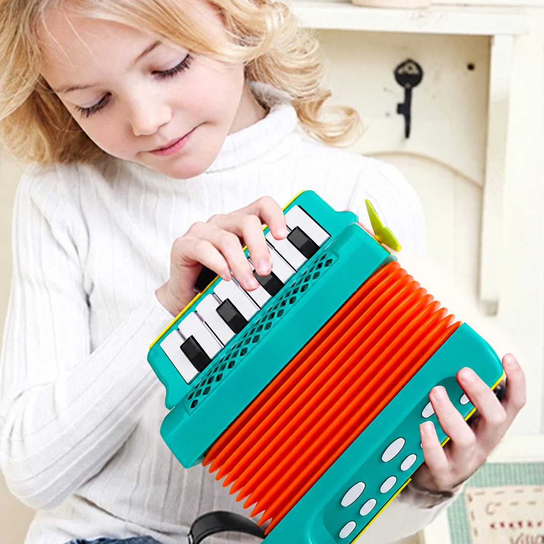Child pressing the keys of a green toy accordion