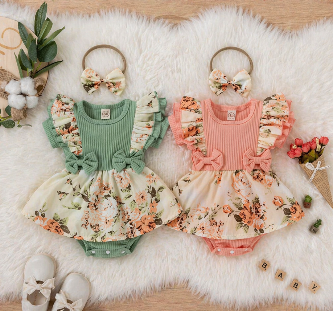 Green and pink floral baby rompers laid side by side with bow headbands