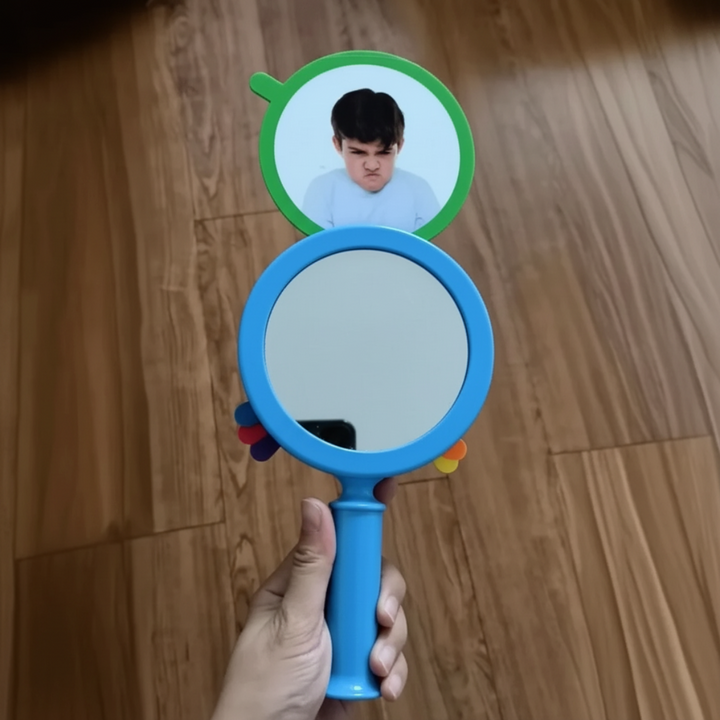 Handheld blue mirror with a green-framed angry expression card above it