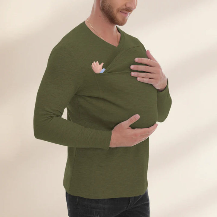 Green V-neck baby carrier shirt shown with a baby in the built-in front pouch.