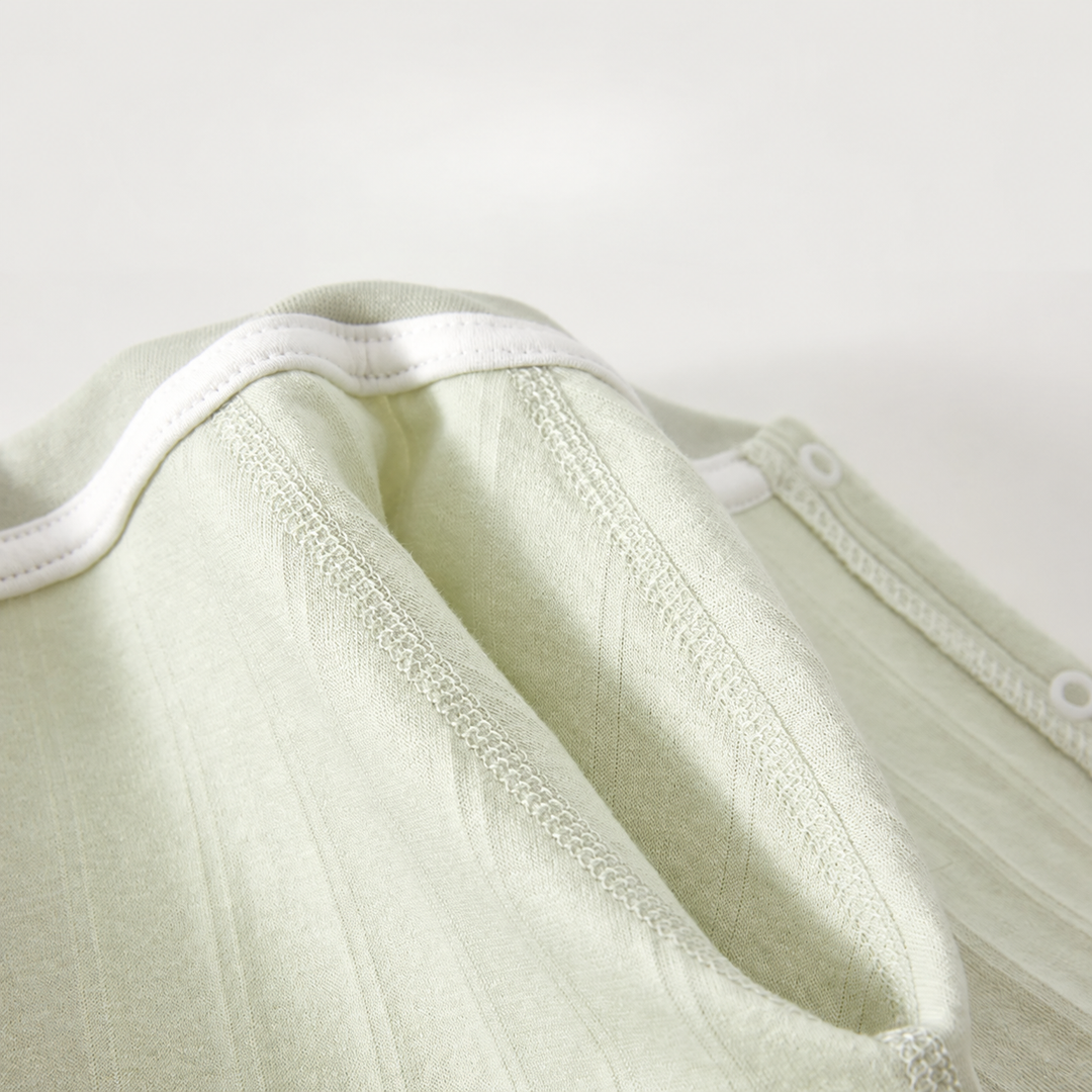 Inside neckline and finished seams of the green cotton baby romper