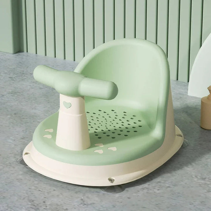 Green baby bath seat with a perforated seat and cream-colored base