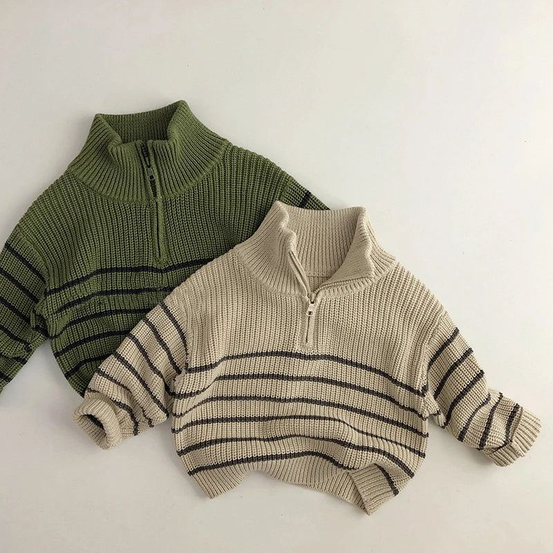 Green and beige striped cotton zip-neck sweaters laid flat together
