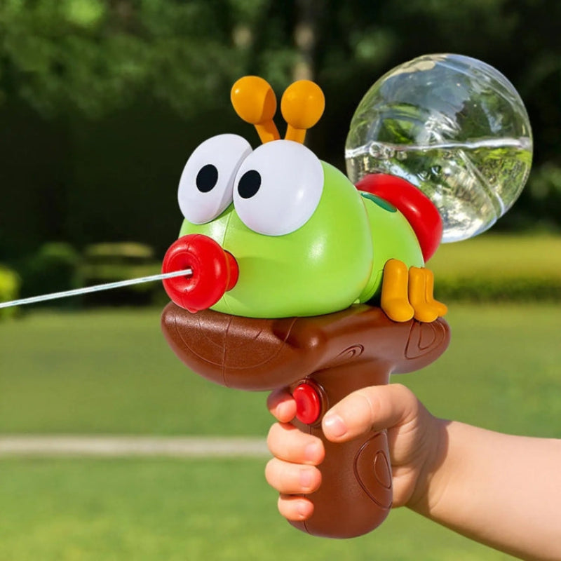 Hand holding a green insect-shaped water gun as it sprays a stream outdoors.