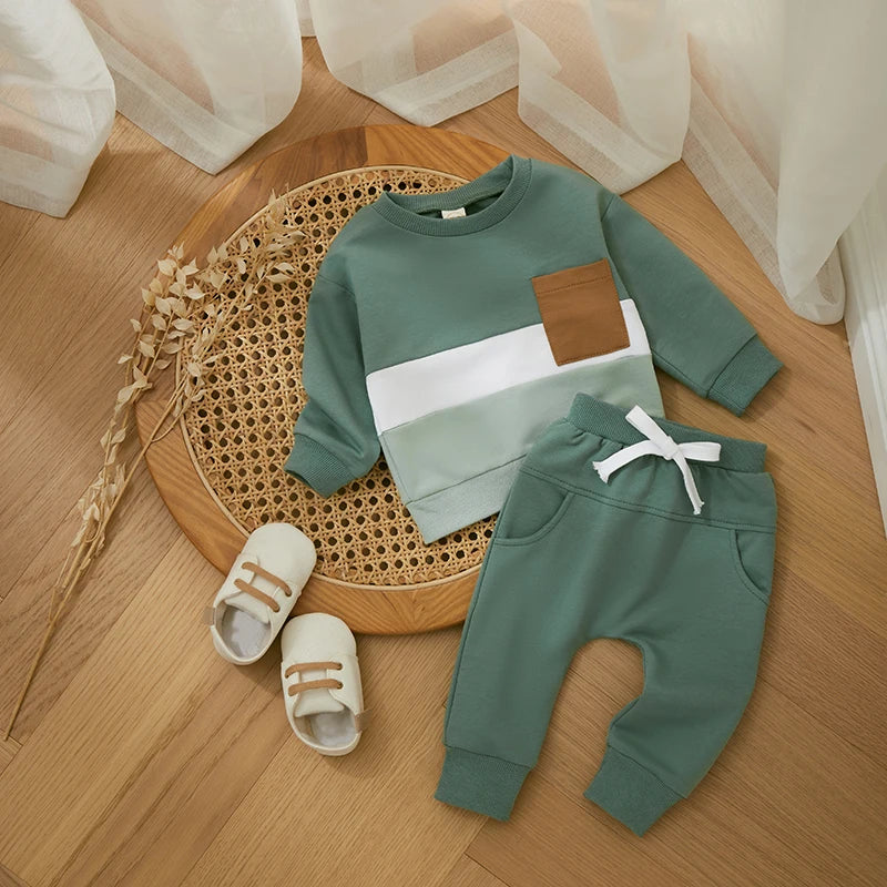 Green two-piece tracksuit with a white chest stripe, tan pocket, and matching drawstring joggers