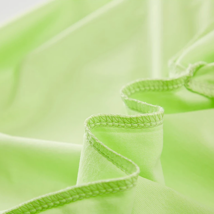 Close-up of green cotton T-shirt fabric with stitched inner seams