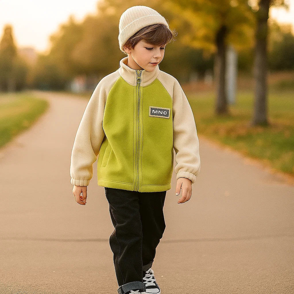 Child wearing the green-and-cream zip-up fleece jacket on an outdoor path