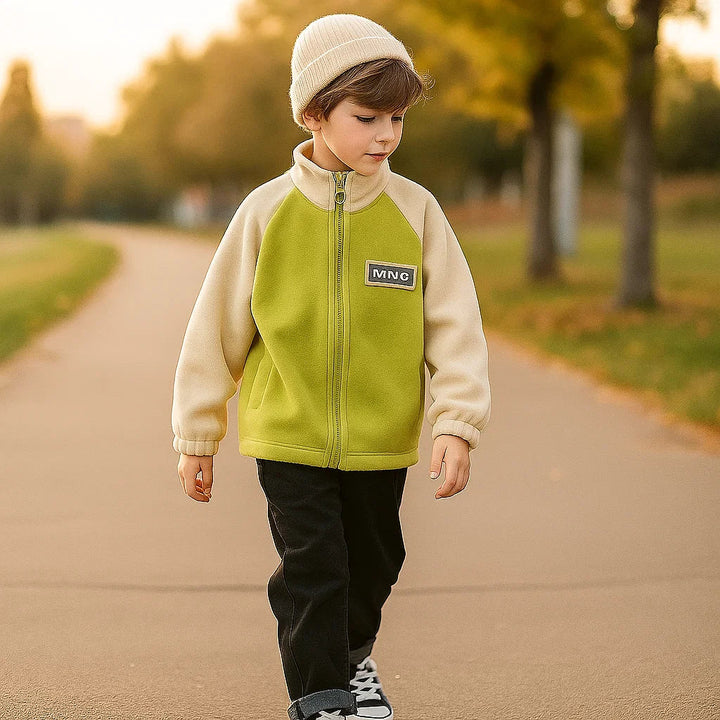 Child wearing the green-and-cream zip-up fleece jacket on an outdoor path