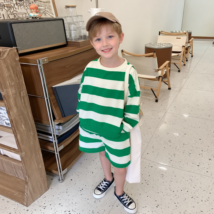 Child wearing a green-and-cream striped long-sleeve top with matching shorts