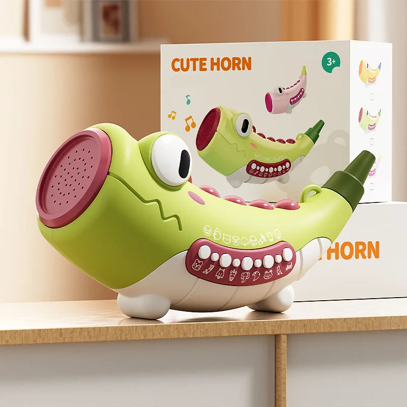 Green crocodile musical toy shown in front of its retail box