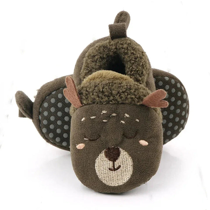 Green deer baby slippers showing antler details and dotted soles.