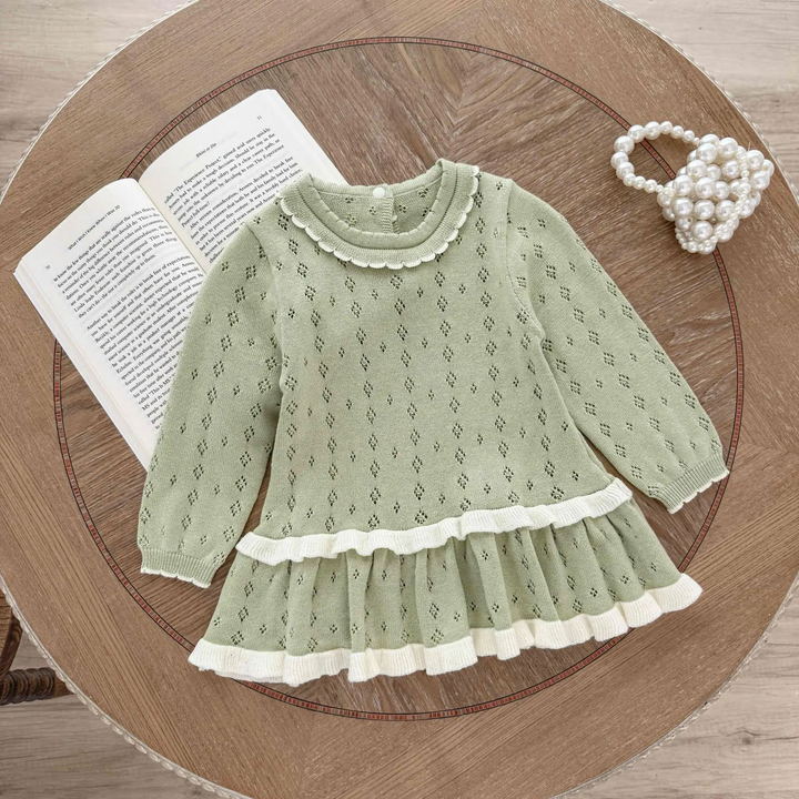 Green long-sleeve knit baby dress with white ruffle edging and a flared skirt