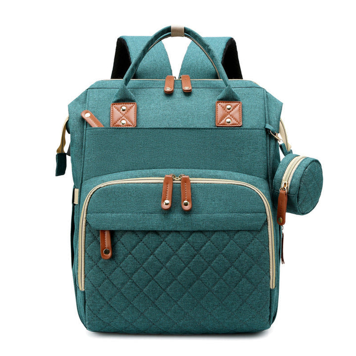 Green diaper backpack with top handles, zippered pockets, and a round side pouch